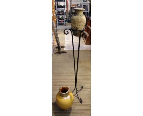 A metal tripod stand containing a decorated vase together with a yellow porcelain vase