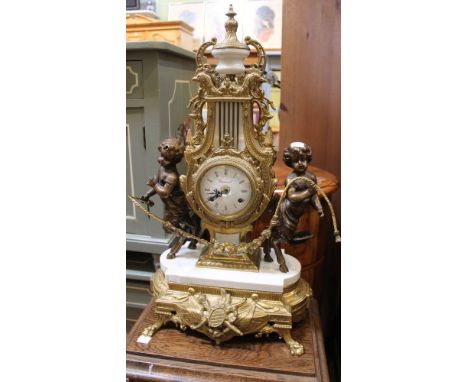 A reproduction French design mantle clock, cast brass lyre design, having satyr supports, the white enamel dial with Roman nu
