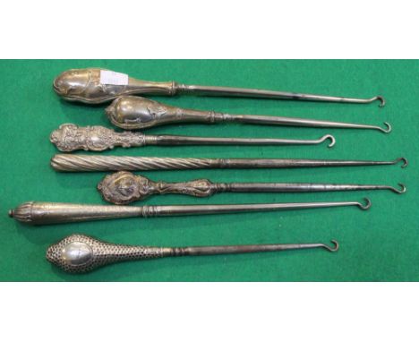 A collection of seven long silver handled button hooks