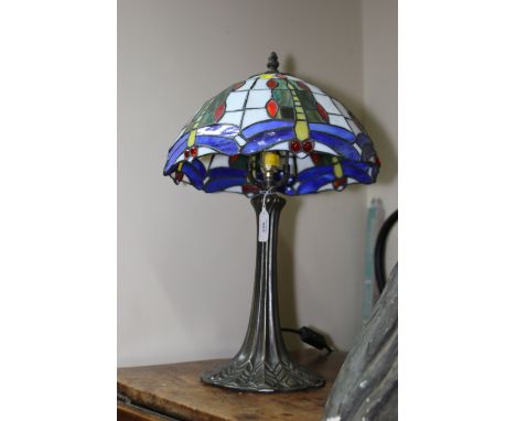 A Tiffany-style table lamp, the panelled shade decorated with dragonflies on a reeded cast metal column and stiff leaf base, 