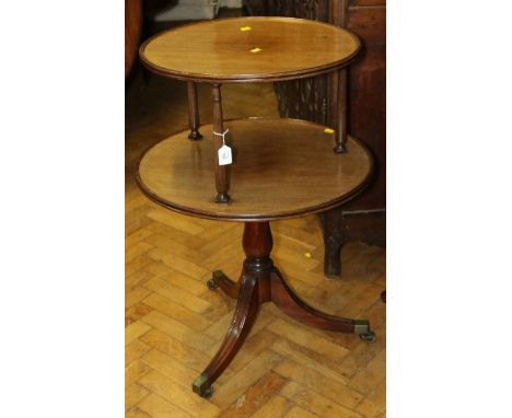 A George IV mahogany two tier circular dumb waiter, with dished tops, raised on tripod supports, 96cm diameter 