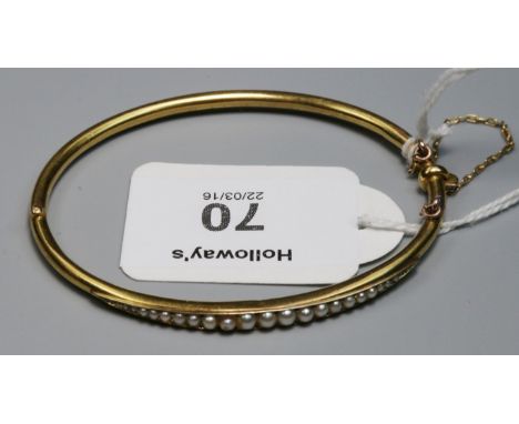 A Victorian half hoop graduated split pearl bangle, to push button hinged clasp