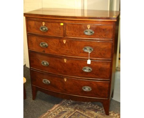 A Regency mahogany bow front chest, of two short and three graduated long drawers, with boxwood escutcheons and brass drop ha