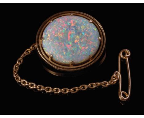 An oval opal brooch, the highly polished stone in claw mounts within double banded rim