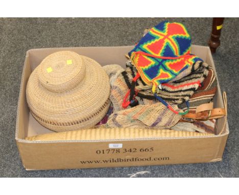 A collection of Papua New Guinea and African textiles, including bilum bags, straw basket and cover, coconut squeezer, and a 