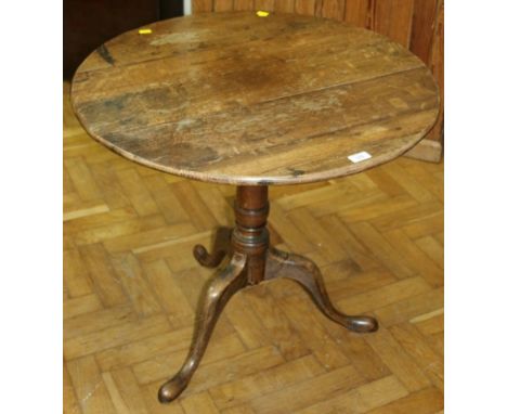 A late 18th century oak tripod table, the circular snap top on baluster turned column, three swept legs and pad feet, 75.5cm 