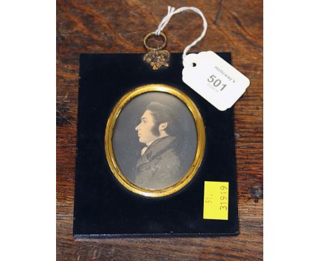 An early 19th century oval portrait silhouette miniature of a gentleman, in frock coat with bodycolour detail, the backing pa