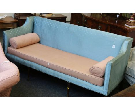 A George IV mahogany legged three seat sofa, with swept cut back arm rests and low back and deep seat, the tapering supports 