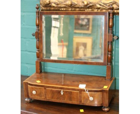 An early 19th century mahogany, crossbanded and strung toilet mirror, the bevelled rectangular plate within ring turned and b