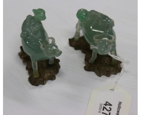 A pair of 19th/20th century Chinese celadon green jade 'boy and buffalo' carved figures, with shaped wooden bases, 5.5 cm (2 