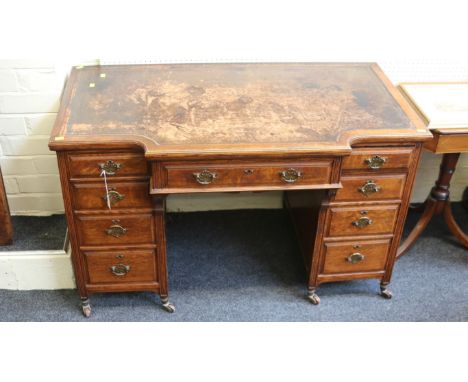 James Shoolbred and Co., an Edwardian oak twin pedestal writing desk, the rectangular swept break front top with leather scri