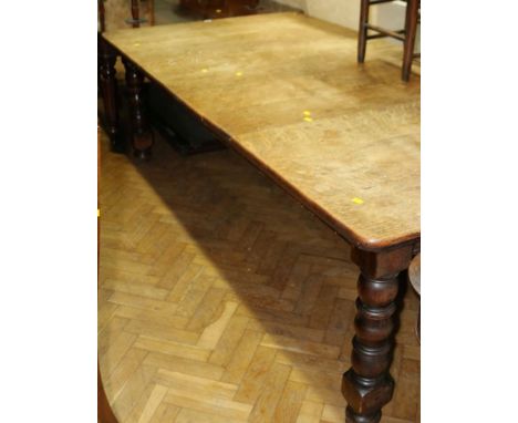 A late Victorian oak extending dining table, the rectangular top with moulded edge and two extra leaves on bobbin, reel and b