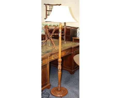 A mid 20th century beech standard lamp, having fluted and leaf carved column and dished circular base, with turquoise cloth s