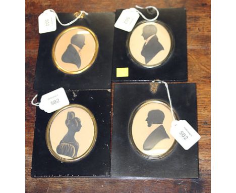 An early 19th century oval silhouette portrait of a lady in a ball gown, with leg of mutton sleeves, her hair in a high bun, 