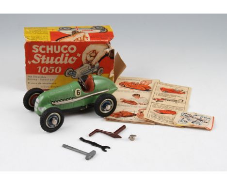 A Schuco 'Studio' 1050 tin plate clockwork car with green body and black underside, with spanner, key, hammer and spare locki