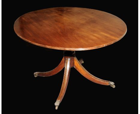 A George III oval mahogany table on central bulbous column and four supports on brass claw feet and castors.