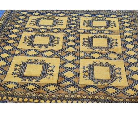 TURKOMAN RUG, gold and black with a tile pattern of six large square guls, on a patterned field, three narrow border stripes,