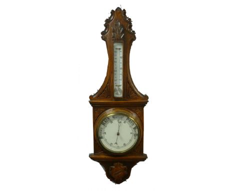 EDWARDIAN CARVED OAK ANEROID BAROMETER, the 8" diameter, set beneath a mercury thermometer to the trunk, housed in a shaped c