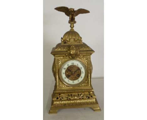 LATE NINETEENTH CENTURY EMBOSSED BRASS MANTEL CLOCK, the 3 1/2" Arabic dial with gilt scroll centre powered by an eight day m