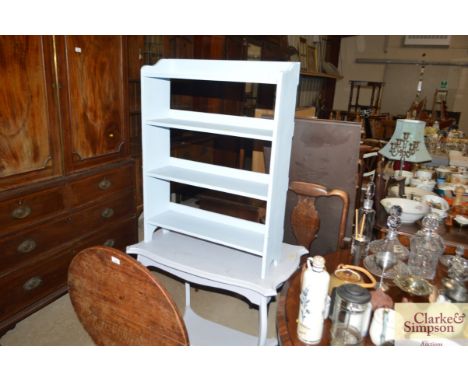 A blue painted open fronted book shelf and a shaped top occasional table