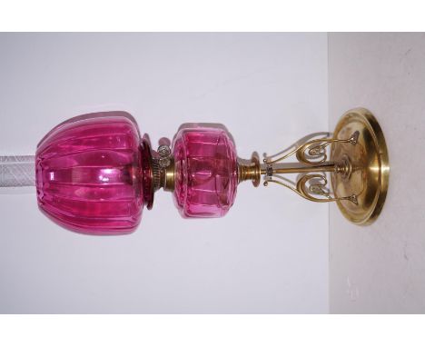 Arts and crafts style oil lamp with cranberry glass shade and reservoir, height 64cm  