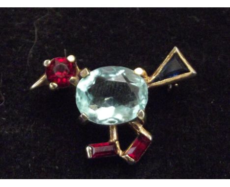Unusual yellow metal pin brooch with three red gem stone, central light blue stone and one other dark blue stone