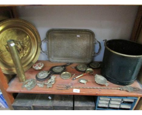 A good shelf of brassware including horse brasses etc