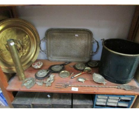 A good shelf of brassware including horse brasses etc