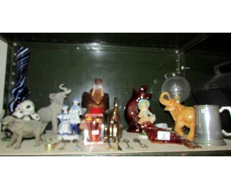 A shelf of miscellaneous figures including elephants etc