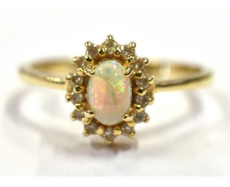 14CT OPAL &amp; DIAMOND HALO RING Central white opal, oval cabochon with very good play of colour, surrounded by a halo of ro