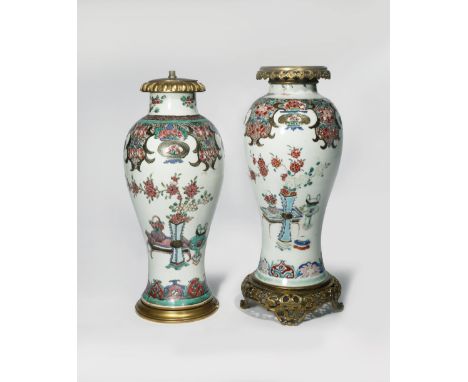 A NEAR PAIR OF CHINESE FAMILLE ROSE VASES 18TH CENTURY The tall baluster-shaped bodies decorated with vases containing pine a
