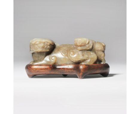A CHINESE GREY AND BROWN JADE 'LION DOG' GROUP LATE MING DYNASTY Formed as a recumbent lion dog turning its head to sinister,