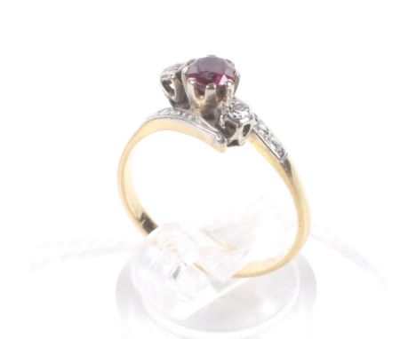 A vintage gold, ruby and diamond cross-over ring. Centred with a round mixed-cut ruby, between small eight-cut diamonds, all 