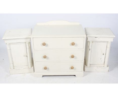 A vintage chest of drawers and a pair of bedside tables. All painted white, the chest of drawers  having three drawers with p