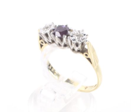 A vintage 18ct gold, ruby and diamond three stone ring. Centred with a round mixed-cut ruby, between tiny eight-cut illusion 