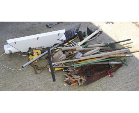 A collection of gardening tools and a Plant Light. The tools including spades, pitchforks, saws, rakes, etc.