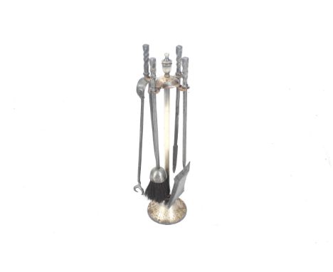 A set of four early 20th century brass forged fire side tools on a stand. H65cm