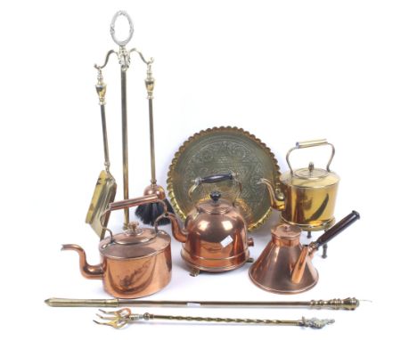A collection of assorted vintage copper and brass items. Including kettles, a fire side set of tools and a Middle Eastern cir