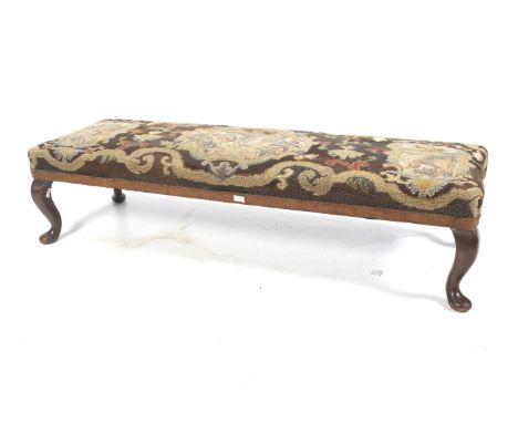 A early 20th century mahogany tapestry embroidered long footstool. On squat cabriole supports, embroidery with bird and flora