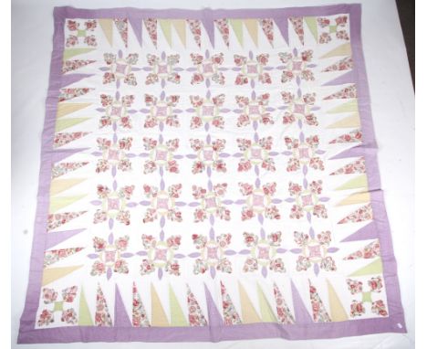 A 20th century large patchwork quilt. Hand quilted, with a reoccurring pattern surrounded by a triangular border, incorporati