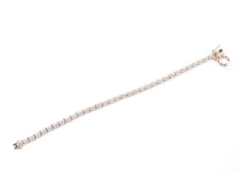 A Chinese parcel gilt white metal and tiny diamond tennis bracelet. With a small opaque-ruby circlet pendant, the push-snap s