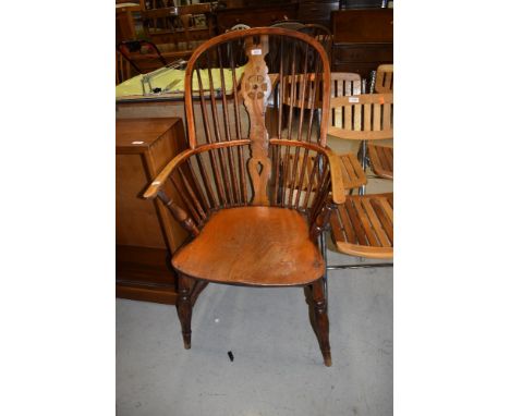 A traditional antique elm seated and steamed ash bow back Windsor chair having wheeled vase back panel