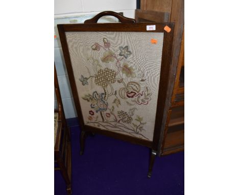 A traditional oak firescreen having embroidered panel