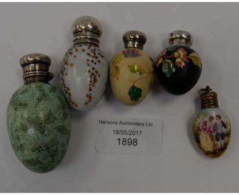 A collection of ceramic scent bottles in the form of eggs, Worcester style, with silver mounts (5) 