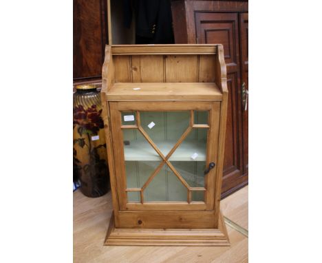 A late Victorian oak corner cabinet, with key, with a contemporary pine wall cupboard, having a decorative glass door (2)