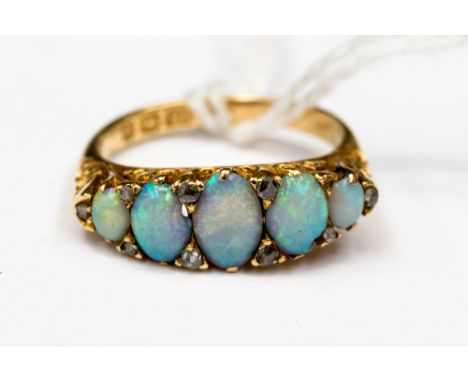 A Victorian opal and diamond 18ct. yellow gold boathead ring, comprising five graduated opals with rose cut diamond chip poin