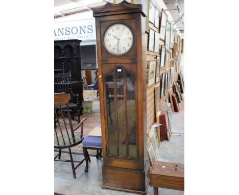 A circa 1930s oak longcase clock with silvered dial