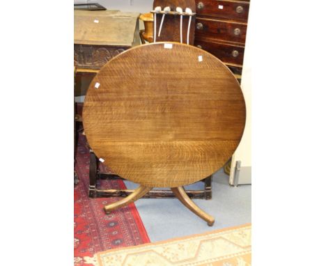 An early 19th century oak tripod table, tilt top