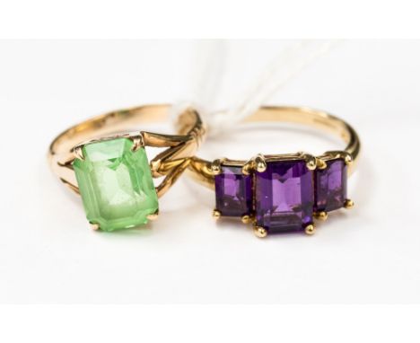 Two 9ct gold rings, one set with three purple rectangular stones, size Q1/2, one set with an emerald cut green stone, size K1