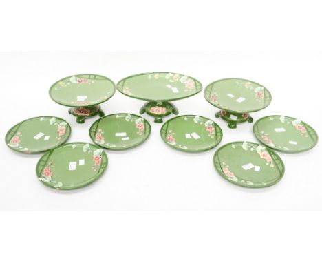 An Art Nouveau Majolica part dessert set, with a floral sprays and geometric design on a green ground, comprising two comport